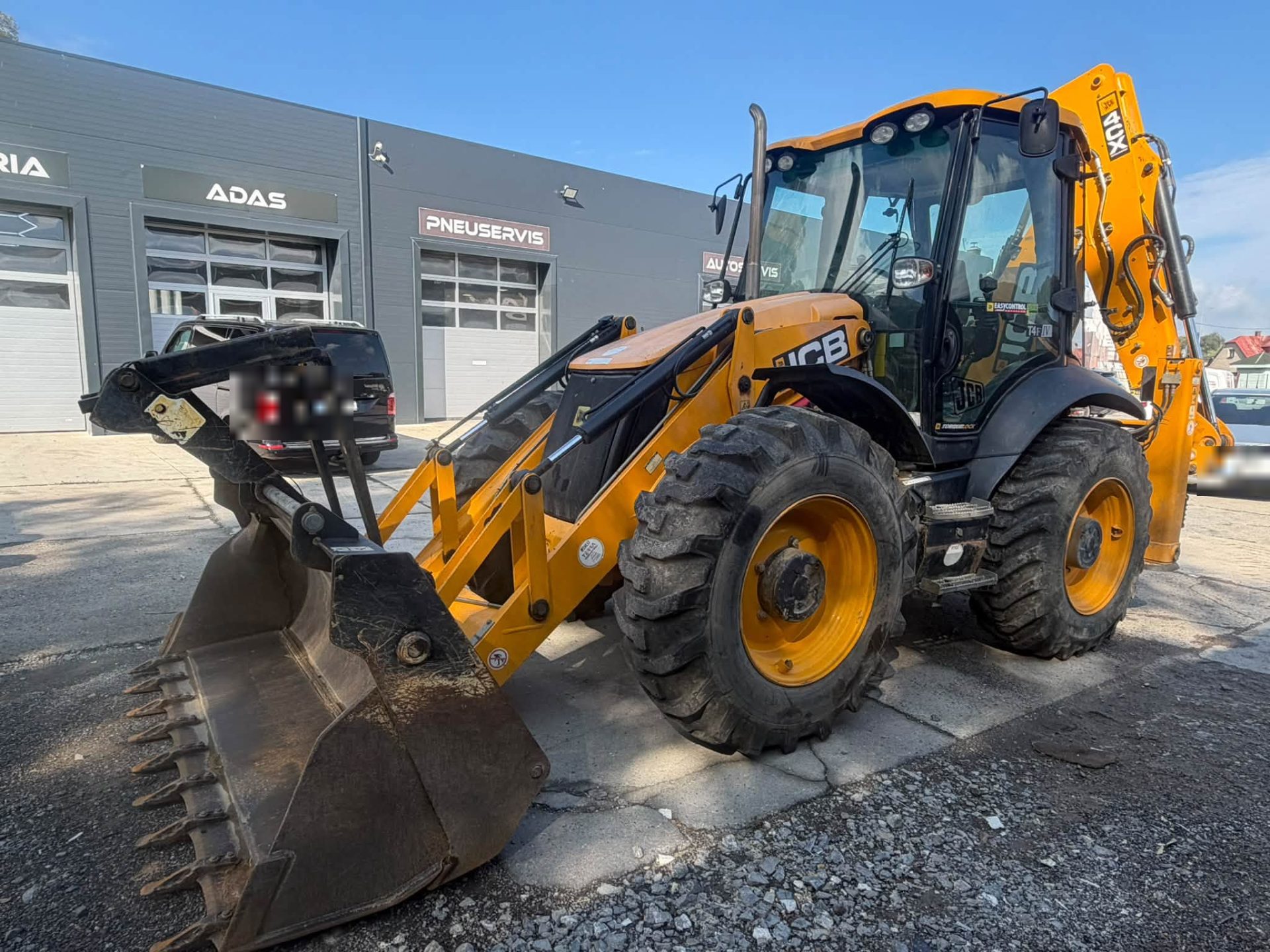 Rýpadlo-nakladač JCB 4CX pred autoservisom Autochiptuning.sk v Čadci