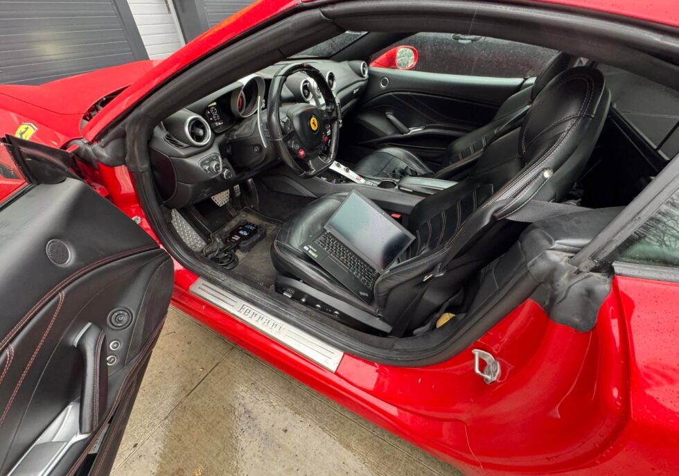 Diagnostika Ferrari s notebookom na sedadle vodiča v dielni v Čadci
